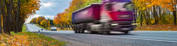 A pink lorry driving at speed