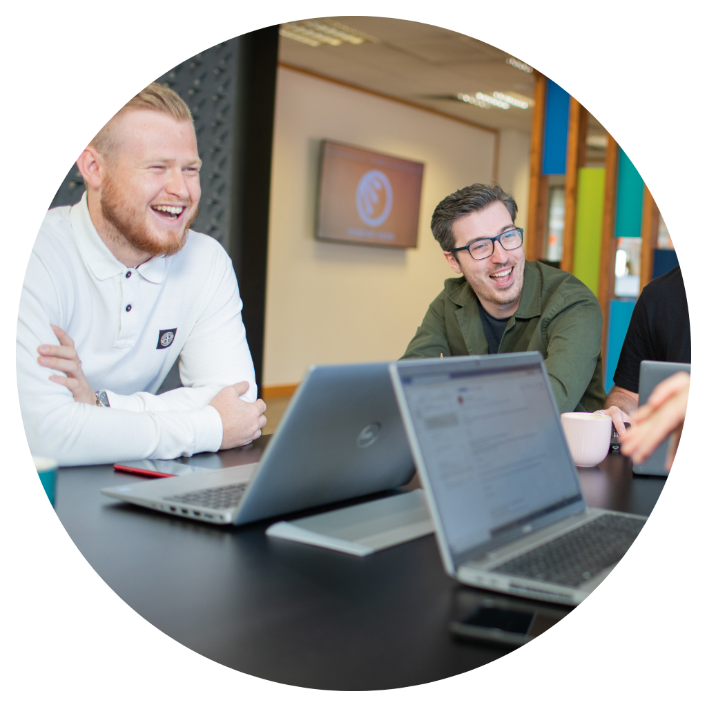 Doug Cameron and Doug Reynolds sat together and smiling with their laptops